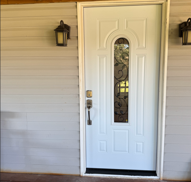 Installed white front door with glass insert.